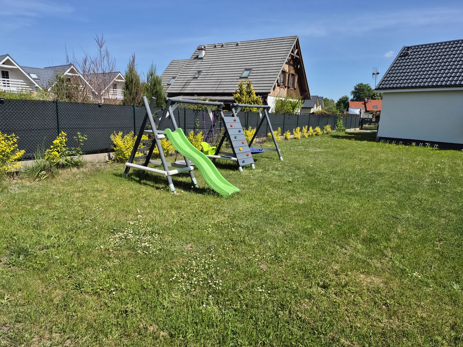 Plac zabaw dla dzieci w ogrodzie aleChata — zjeżdżalnia i huśtawki