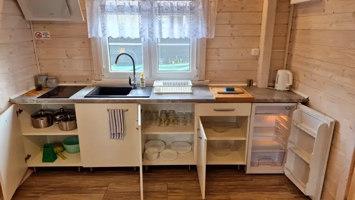 Otwarte szafki kuchenne z zastawą stołową